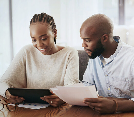 couple looking at documents and a tablet