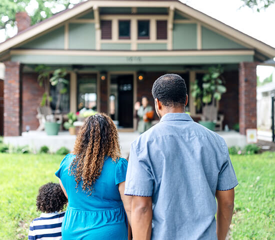 family walking up to new home
