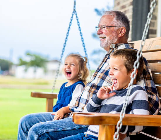grandfather with 2 kids on porch swing