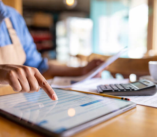 businessperson using tablet and calculator