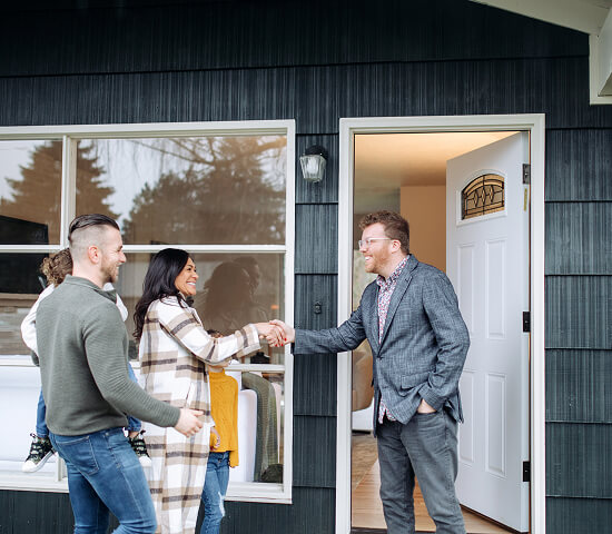 family shaking hands with a realtor
